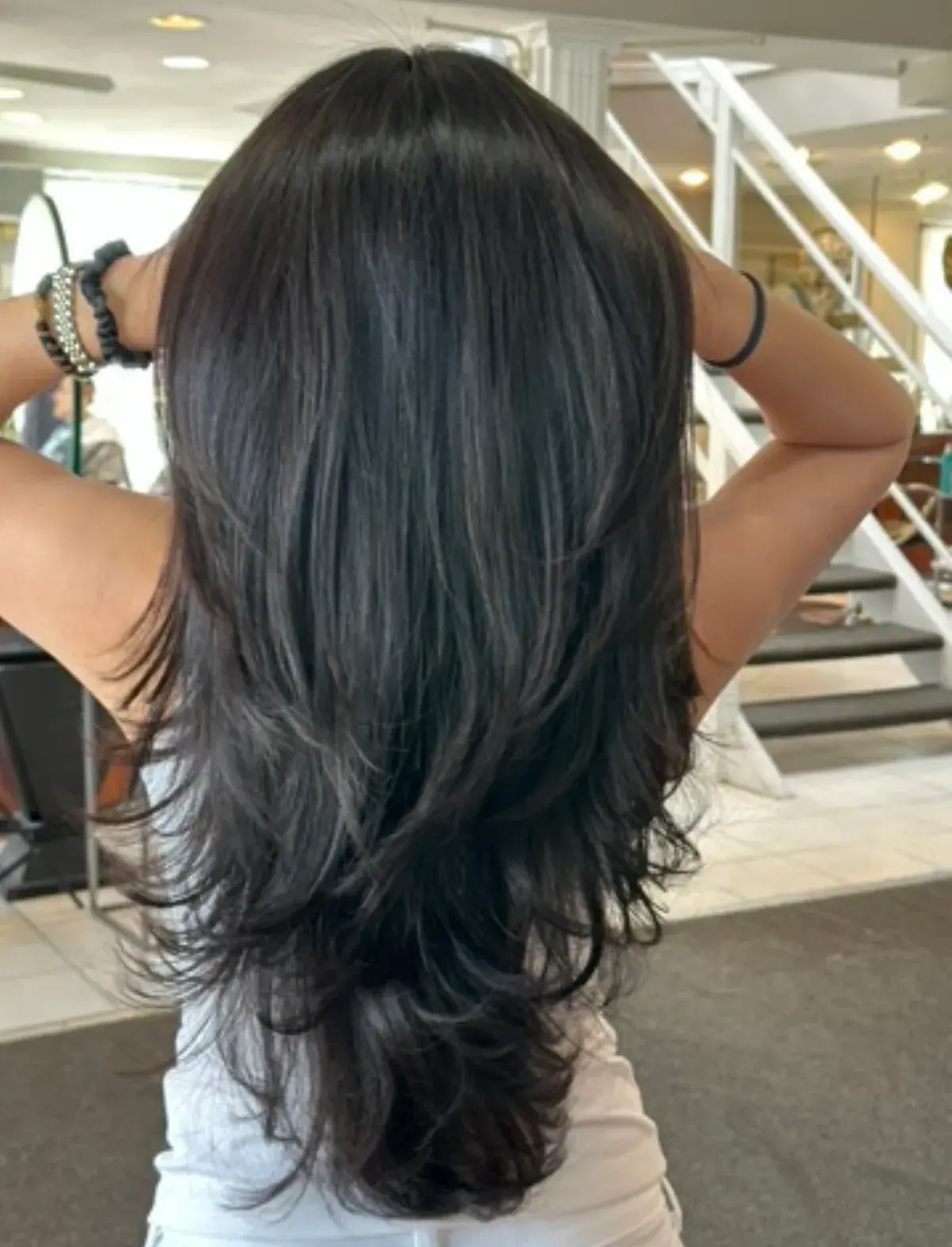 Long dark custom layered cut, styled with soft movement