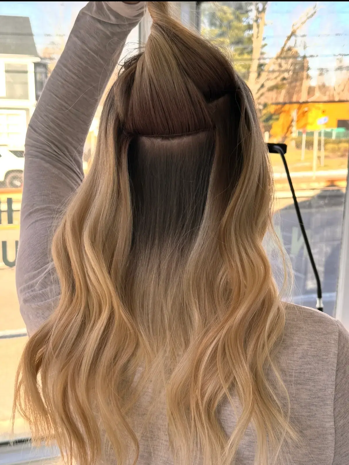 Long blonde waves during a two-row Invisible Bead Extensions install